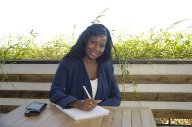 genç çekici siyah Afrikalı-Amerikalı kadın açık havada oturup bir