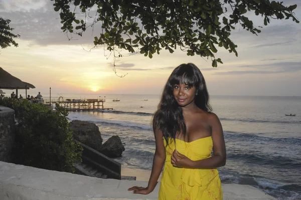 Glamorous African American black woman in chic and elegant summer dress posing relaxed on summer sunset beach — Stock Photo, Image