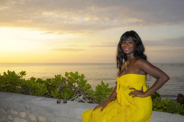 Femme noire afro-américaine glamour en robe d'été chic et élégante posant détendue sur la plage de coucher de soleil d'été — Photo