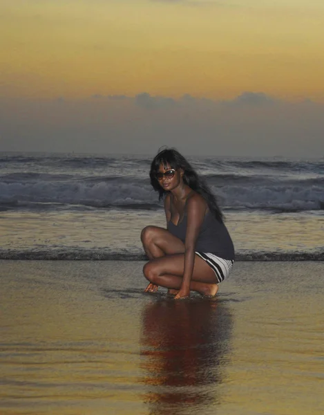 Uvolnil atraktivní afroamerické černá žena chůze na sunset beach se těší vody a písku — Stock fotografie