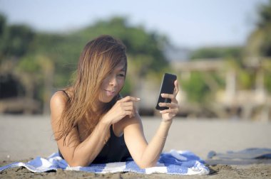 mutlu Asyalı kadın cep telefonuyla rahat eğleniyor selfie portre fotoğraf çekme