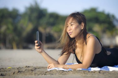 mutlu Asyalı kadın cep telefonuyla rahat eğleniyor selfie portre fotoğraf çekme