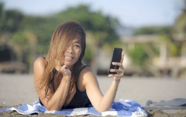 mutlu Asyalı kadın cep telefonuyla rahat eğleniyor selfie portre fotoğraf çekme