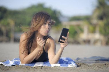 mutlu Asyalı kadın cep telefonuyla rahat eğleniyor selfie portre fotoğraf çekme