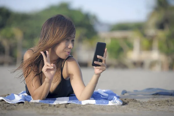 Feliz mujer asiática utilizando el teléfono móvil tomando foto retrato selfie divertirse relajado — Foto de Stock