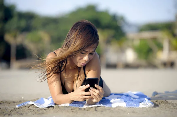 Krásná a šťastná Asijské žena pomocí textových zpráv mobilního telefonu na internetu sociální média usmívající se uvolnil — Stock fotografie