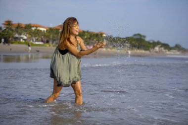 rahat gülümseyen genç güzel ve seksi mutlu Asyalı kadın Bali Asya'da tropik sahilde eğleniyor
