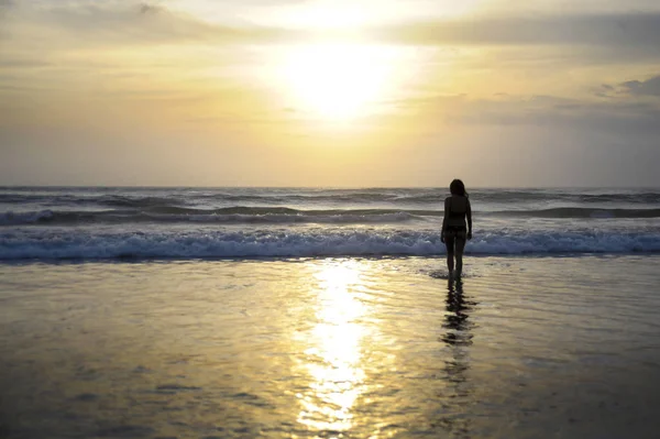 Ufukta deniz manzara günbatımı muhteşem güneş ve dramatik turuncu gökyüzü ile genç aktif kadın