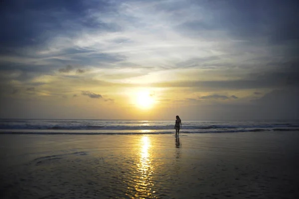 Young woman on sea landscape sunset horizon with amazing sun and dramatic orange sky — Stock Photo, Image