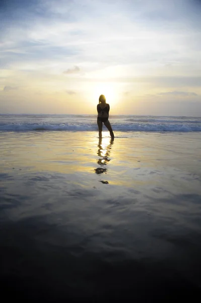 Jovem mulher no horizonte de pôr do sol paisagem do mar com sol incrível e dramático céu laranja — Fotografia de Stock