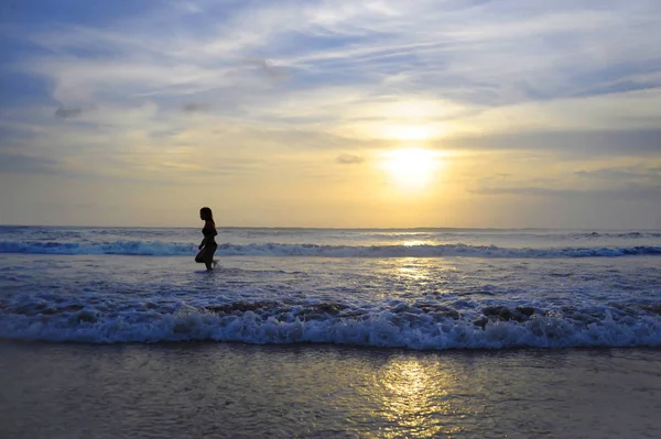 Wanita muda aktif di laut pemandangan matahari terbenam cakrawala dengan matahari yang menakjubkan dan langit jeruk dramatis — Stok Foto