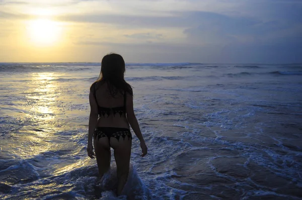 Actieve jongedame aan zee landschap sunset horizon met verbazingwekkende zon en dramatische oranje hemel — Stockfoto