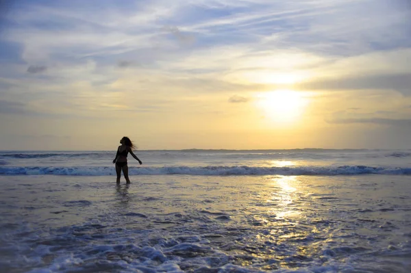 Ufukta deniz manzara günbatımı muhteşem güneş ve dramatik turuncu gökyüzü ile genç aktif kadın