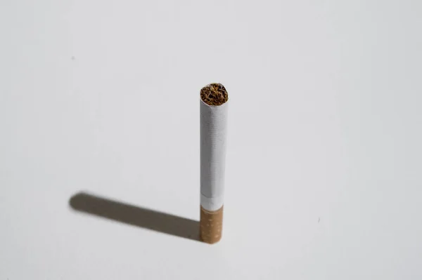 Cigarette and shadow isolated on white background in unhealthy habit of smoking addiction concept — Stock Photo, Image