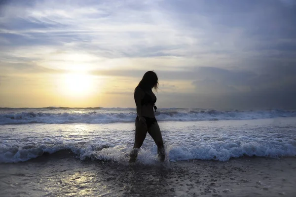 Giovane donna attiva sul mare paesaggio orizzonte tramonto con sole incredibile e drammatico cielo arancione — Foto Stock