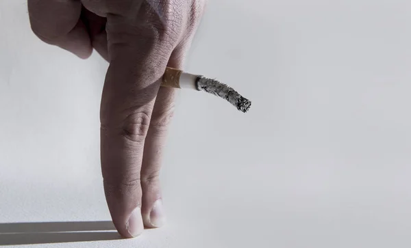 Close up man hand with burning cigarette as penis in smoking cau — Stock fotografie