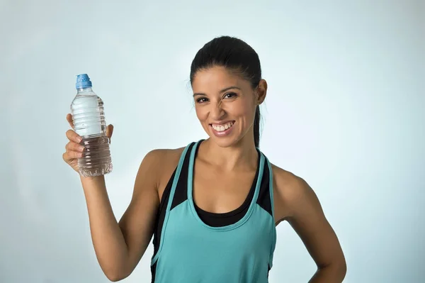 Mujer deportiva latina feliz y atractiva en ropa de fitness sosteniendo botella de agua potable sonriendo fresco y alegre — Foto de Stock