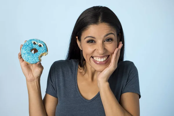 Feliz atraente mulher latina sorrindo animado segurando donut açúcar isolado em fundo claro em abuso de açúcar — Fotografia de Stock