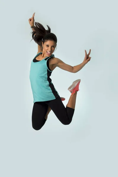 Young attractive and happy Latin sport woman jumping excited and cheerful in gym exercise workout healthy lifestyle — Stock Photo, Image