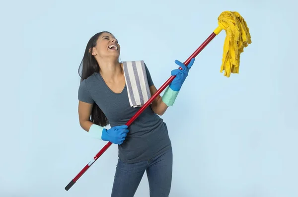 Νεαρή ελκυστική ευτυχισμένη Λατινική γυναίκα στο πλύσιμο γάντια κρατώντας σφουγγαρίστρα διασκεδάζοντας τραγουδώντας και παίζοντας κιθάρα αέρα ενθουσιασμένοι — Φωτογραφία Αρχείου