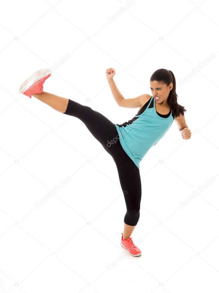 young attractive and furious latin sport woman in fight and kick boxing training workout throwing aggressive kick attack