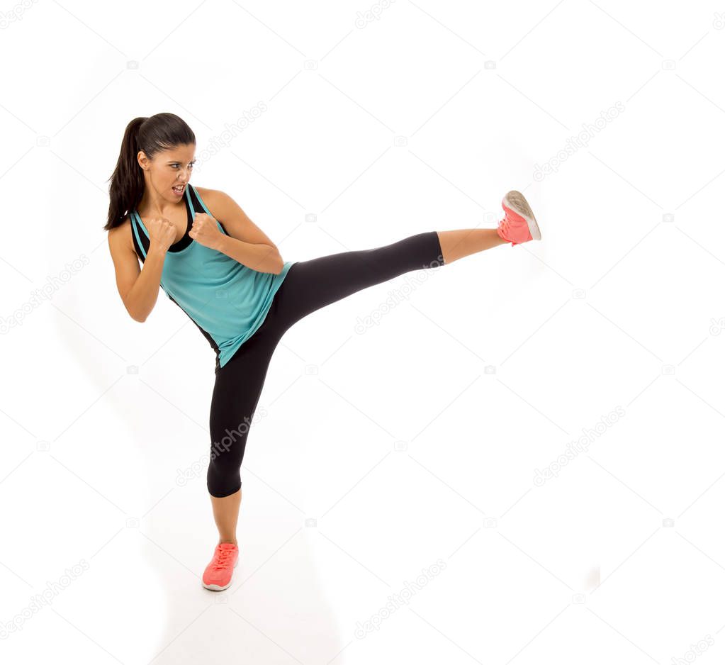 young attractive and furious latin sport woman in fight and kick boxing training workout throwing aggressive kick attack
