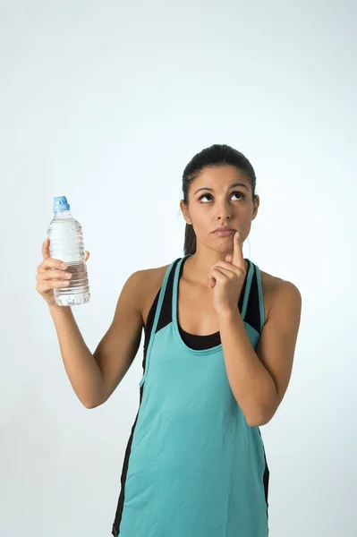Joven atractivo y hermoso latina deporte mujer celebración agua de botella pensando si beber más — Foto de Stock