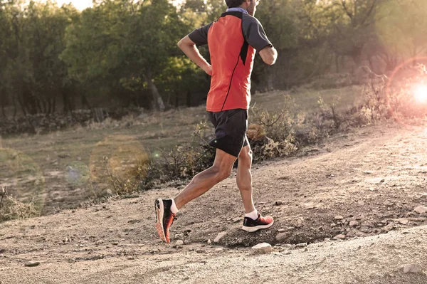 Deportista con piernas atléticas y musculosas arrancadas corriendo cuesta arriba fuera de la carretera en entrenamiento de jogging — Foto de Stock
