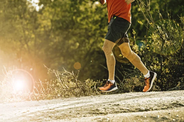 Sport man met geripte atletisch en gespierde benen lopen bergafwaarts Off-Road in opleiding training joggen — Stockfoto