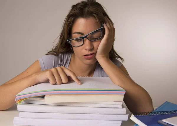 Giovane attraente e bella ragazza studentessa stanca appoggiata sui libri scolastici mucchio sonno stanco ed esausto dopo lo studio — Foto Stock