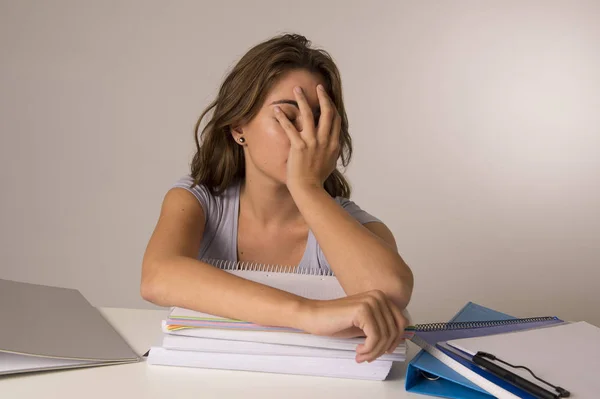 Giovane attraente e bella ragazza studentessa stanca appoggiata sui libri scolastici mucchio sonno stanco ed esausto dopo lo studio — Foto Stock