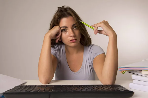 Молодая привлекательная студентка или рабочая женщина, сидящая за компьютером в стрессе выглядит уставшей и скучной — стоковое фото