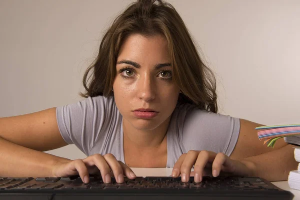 Молода приваблива студентка або робоча жінка, сидячи за комп'ютерним столом у стресі, виглядає втомленою і нудною — стокове фото