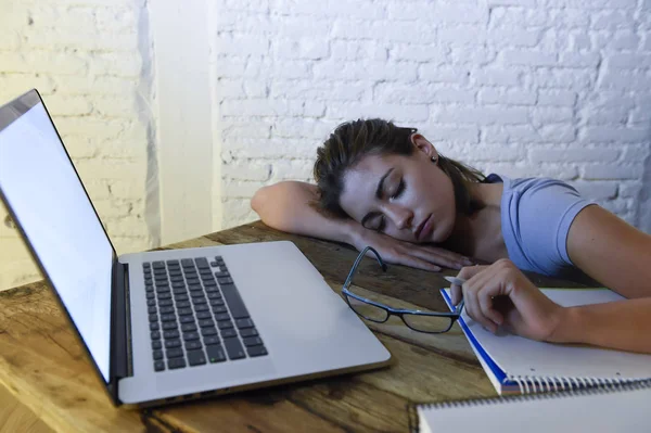 Jonge mooie en vermoeide student meisje slaapt een dutje, liggend op home laptop computerbureau uitgeput en verspild uitgaven nacht studeren — Stockfoto