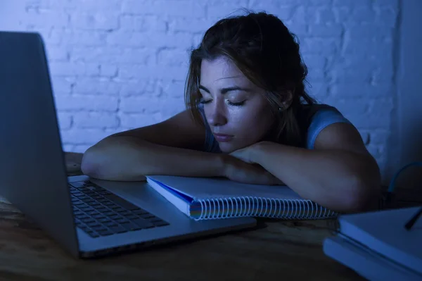 Ung vacker och trött student tjej sover tar en tupplur liggande på hem laptop dator skrivbord utmattad och bortkastade utgifter natt studerar — Stockfoto