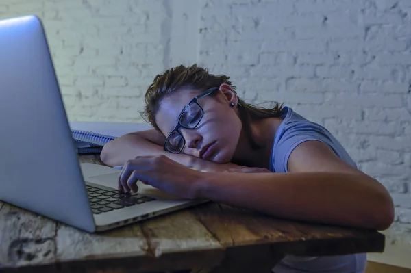 Mladá, krásná a unavená student dívka spí, zdřímnout, ležící na stole domácí přenosný počítač k vyčerpání a zbytečně výdajů noci studovat — Stock fotografie