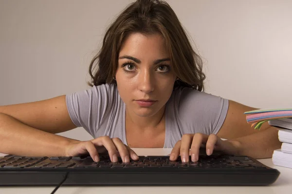 Jeune belle étudiante fille ou femme au travail tapant sur le clavier de l'ordinateur regardant concentré et concentré dans le travail acharné — Photo