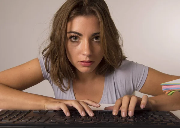 Jeune belle étudiante fille ou femme au travail tapant sur le clavier de l'ordinateur regardant concentré et concentré dans le travail acharné — Photo