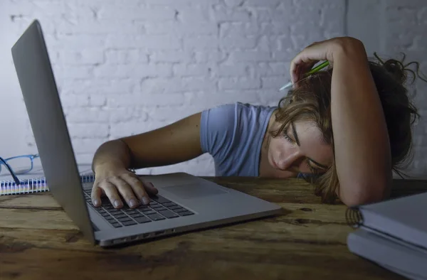 Mladá, krásná a unavená student dívka spí, zdřímnout, ležící na stole domácí přenosný počítač k vyčerpání a zbytečně výdajů noci studovat — Stock fotografie