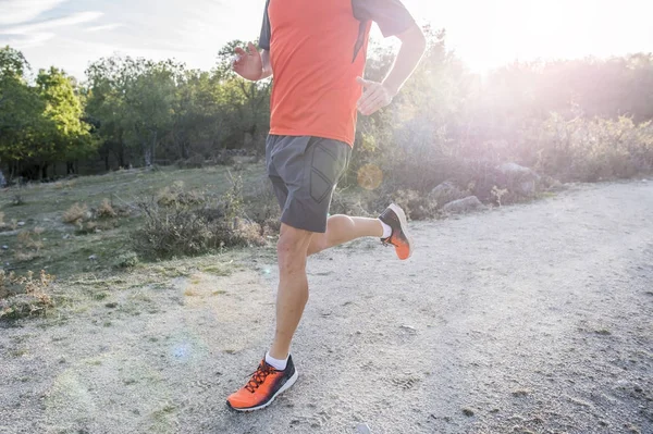 Homem do esporte com pernas atléticas e musculares rasgadas correndo subida — Fotografia de Stock