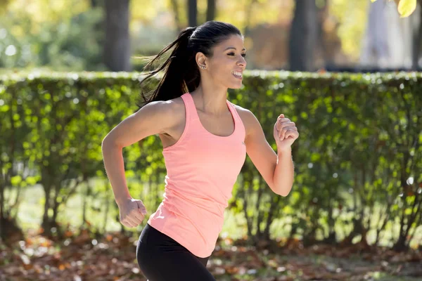 Mujer corredora atractiva y feliz en la ropa deportiva de otoño correr y entrenar en correr al aire libre entrenamiento en el parque de la ciudad — Foto de Stock