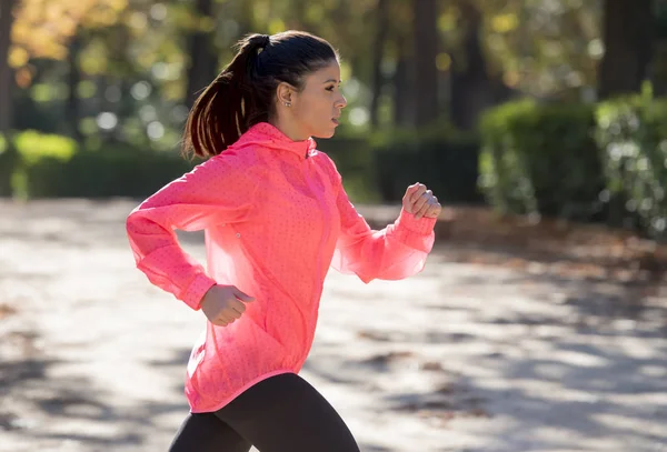 Mujer corredora atractiva y feliz en ropa deportiva de otoño corriendo un — Foto de Stock