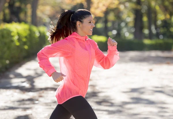 Mujer corredora atractiva y feliz en ropa deportiva de otoño corriendo un — Foto de Stock