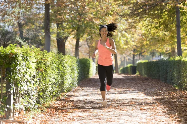 Mujer corredora atractiva y feliz en ropa deportiva de otoño corriendo un — Foto de Stock