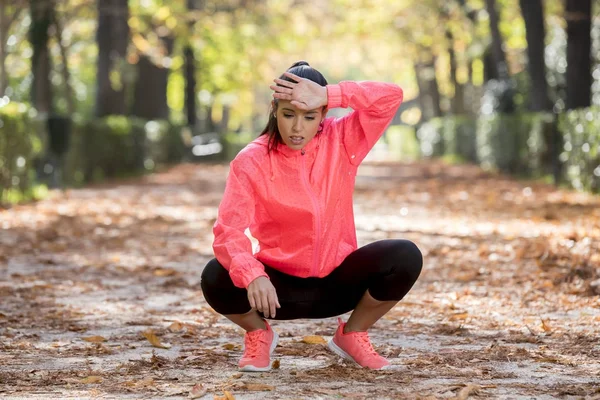 Atraktif wanita olahraga di pelari olahraga bernapas terengah-engah dan mengambil istirahat lelah dan lelah setelah menjalankan latihan di taman musim gugur — Stok Foto