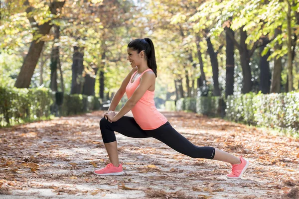 Hermosa mujer deporte hispano en ropa deportiva estiramiento cuerpo siguiente sonriente feliz haciendo ejercicios de flexibilidad — Foto de Stock