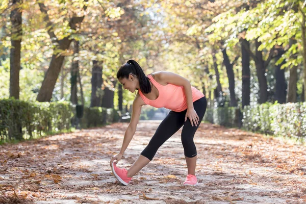 Hermosa mujer deporte hispano en ropa deportiva estiramiento cuerpo siguiente sonriente feliz haciendo ejercicios de flexibilidad — Foto de Stock