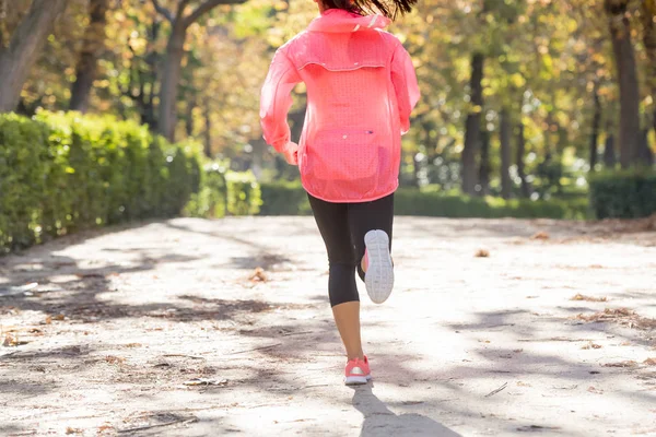 Aantrekkelijk en gelukkig runner vrouw in herfst sportkleding uitgevoerd en training over joggen buiten training in stadspark — Stockfoto