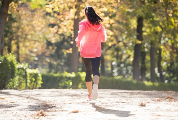 Mujer corredora atractiva y feliz en la ropa deportiva de otoño correr y entrenar en correr al aire libre entrenamiento en el parque de la ciudad — Foto de Stock