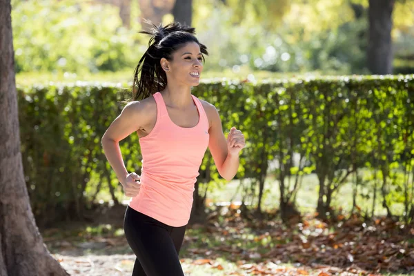 attractive and happy runner woman in Autumn sportswear running and training on jogging outdoors workout in city park